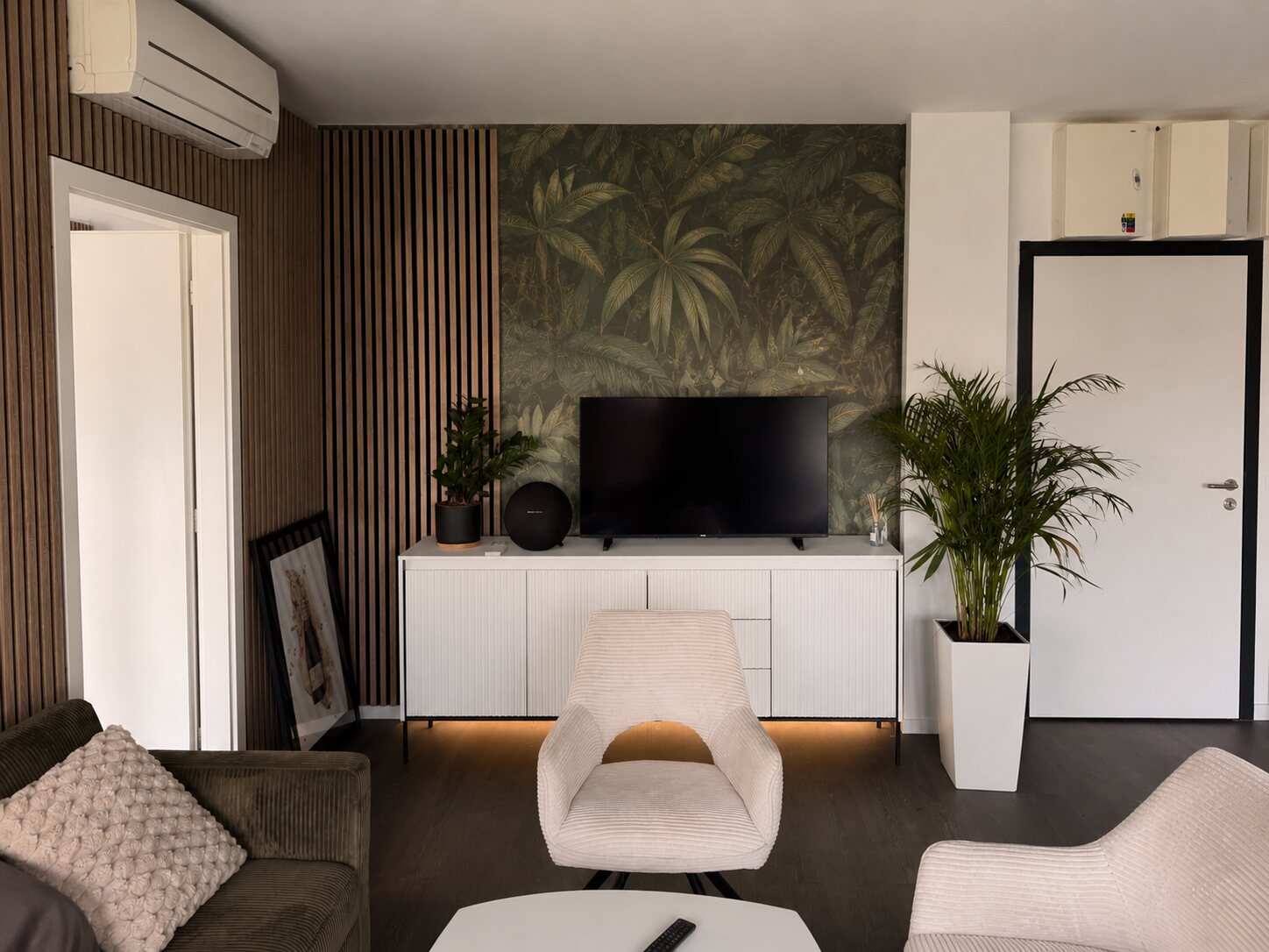 Obývacia izba apartmánu Z2 s dreveným obkladom a tropickou tapetou